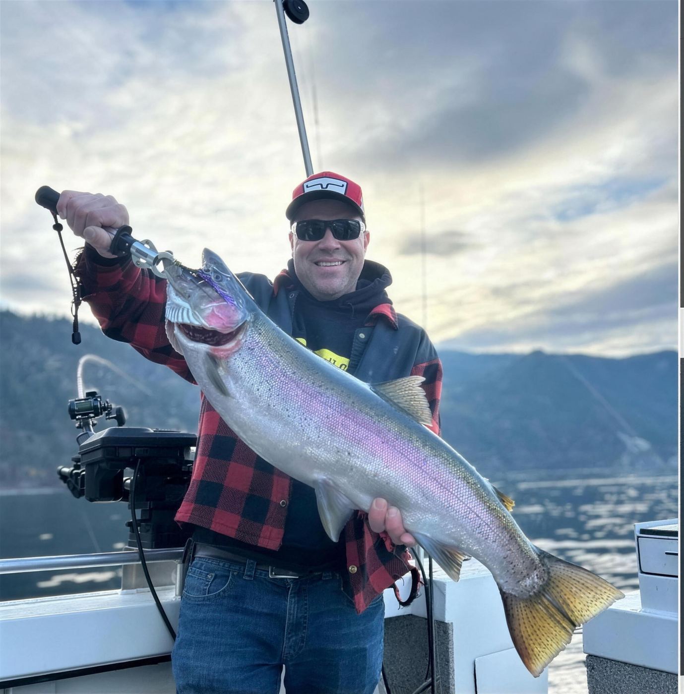 Rainbow trout held up with the Okanagan hills behind
