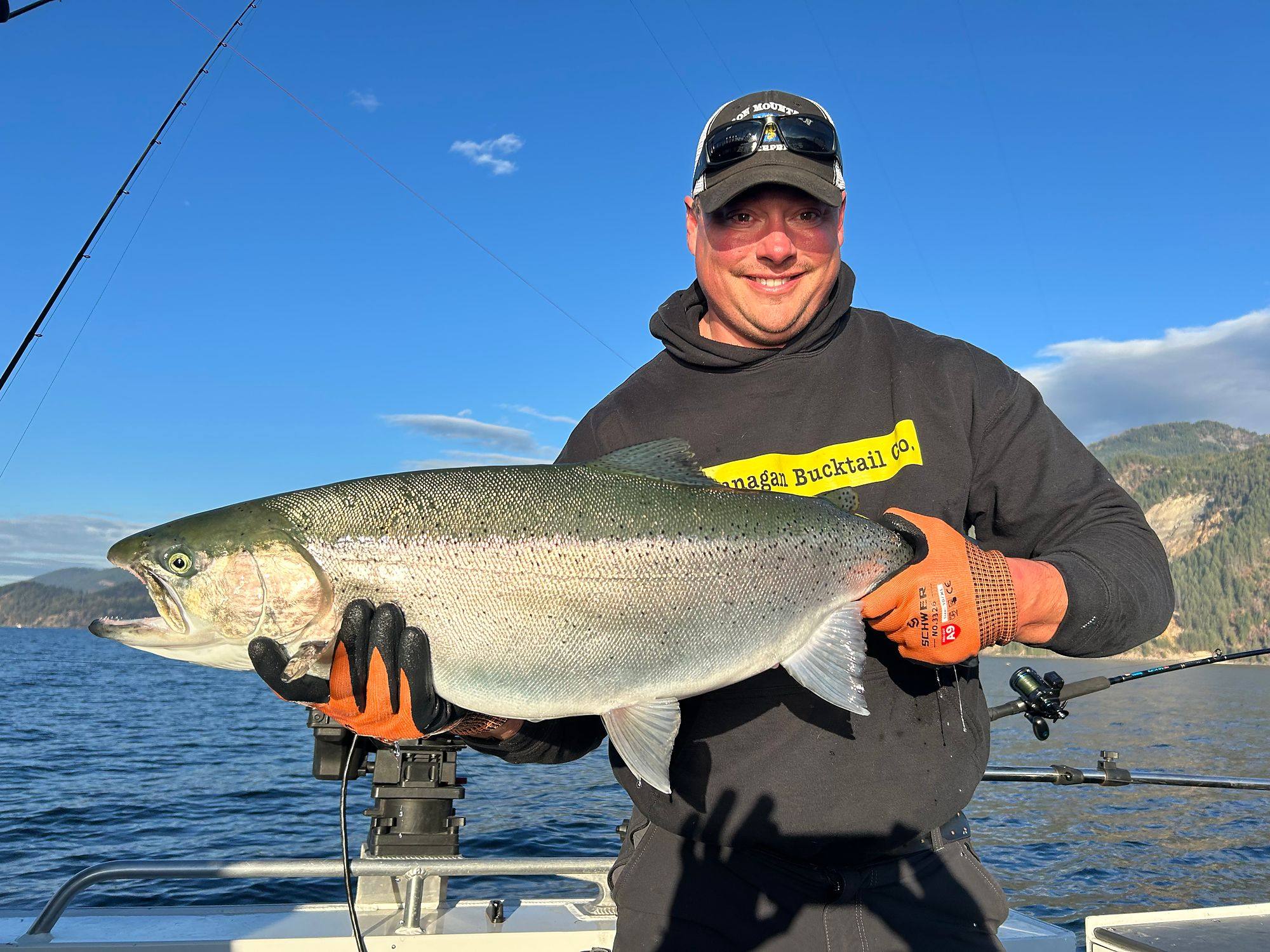 Captain Geoff Hartland holding a large Okanagan Lake rainbow trout on the boat