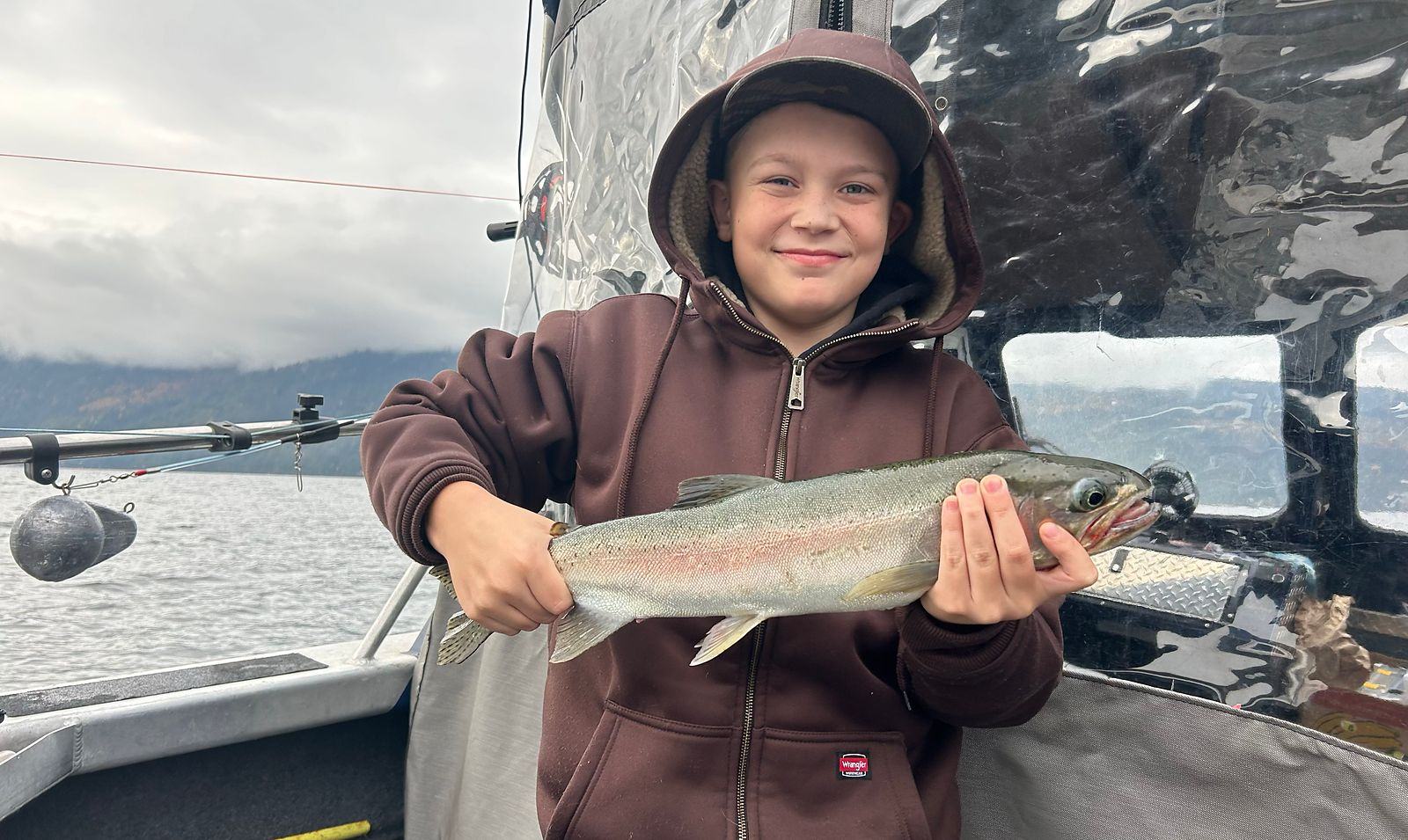 Child holding a rainbow trout on a half day charter