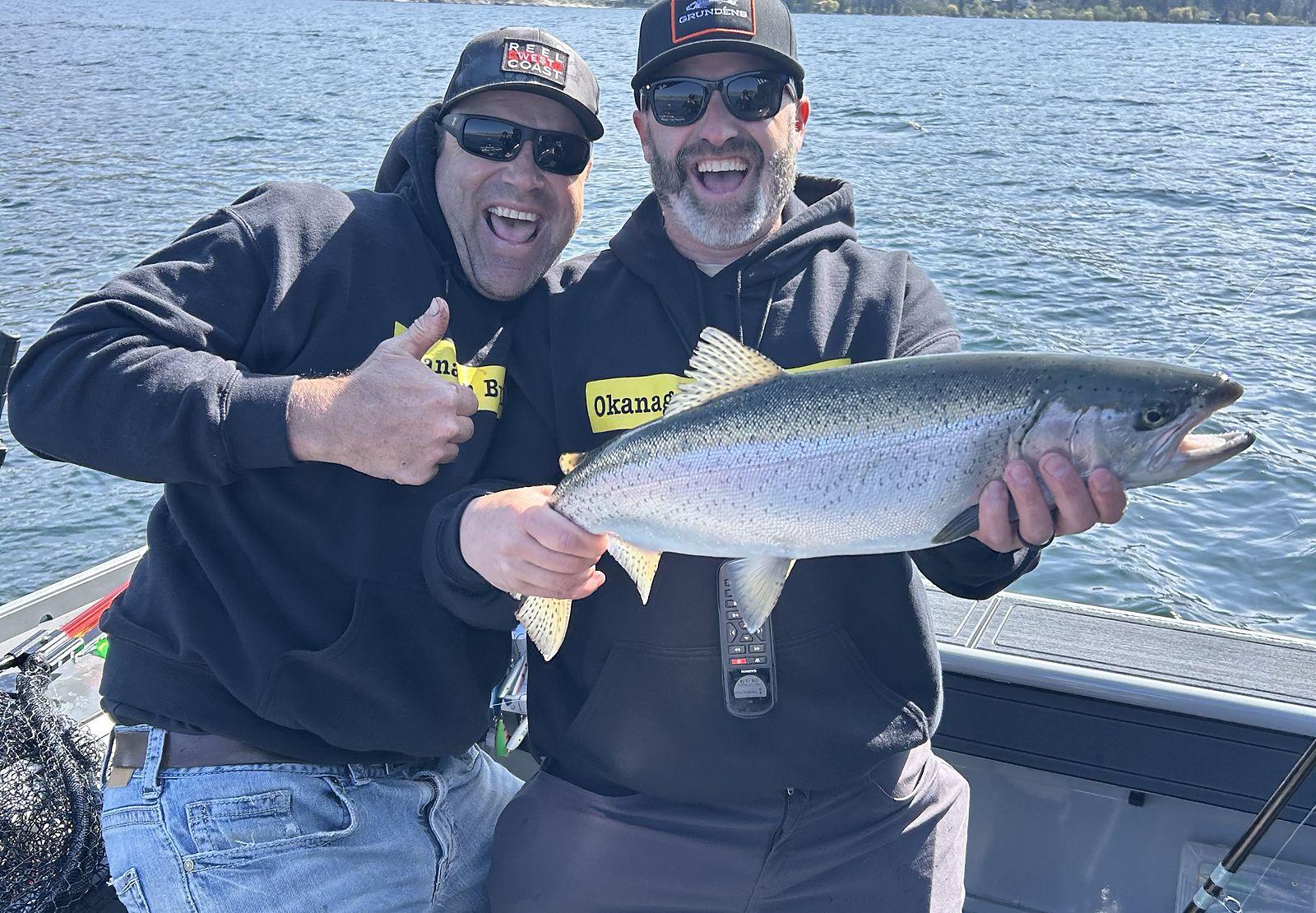 Two anglers with a rainbow trout on a Kelowna fishing charter